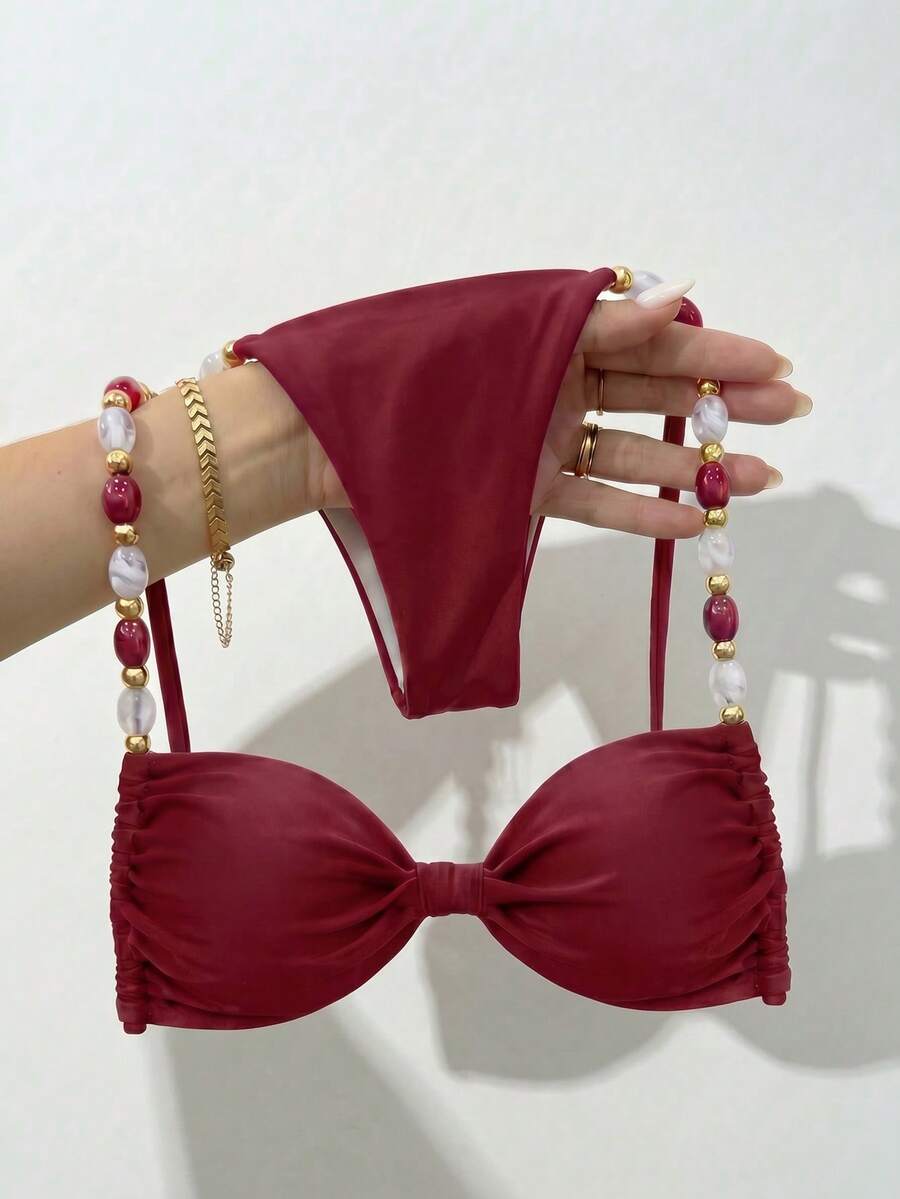 Women's green halter neck bikini set featuring color-block beaded shoulder straps, back tie detail, and high cut bottoms.