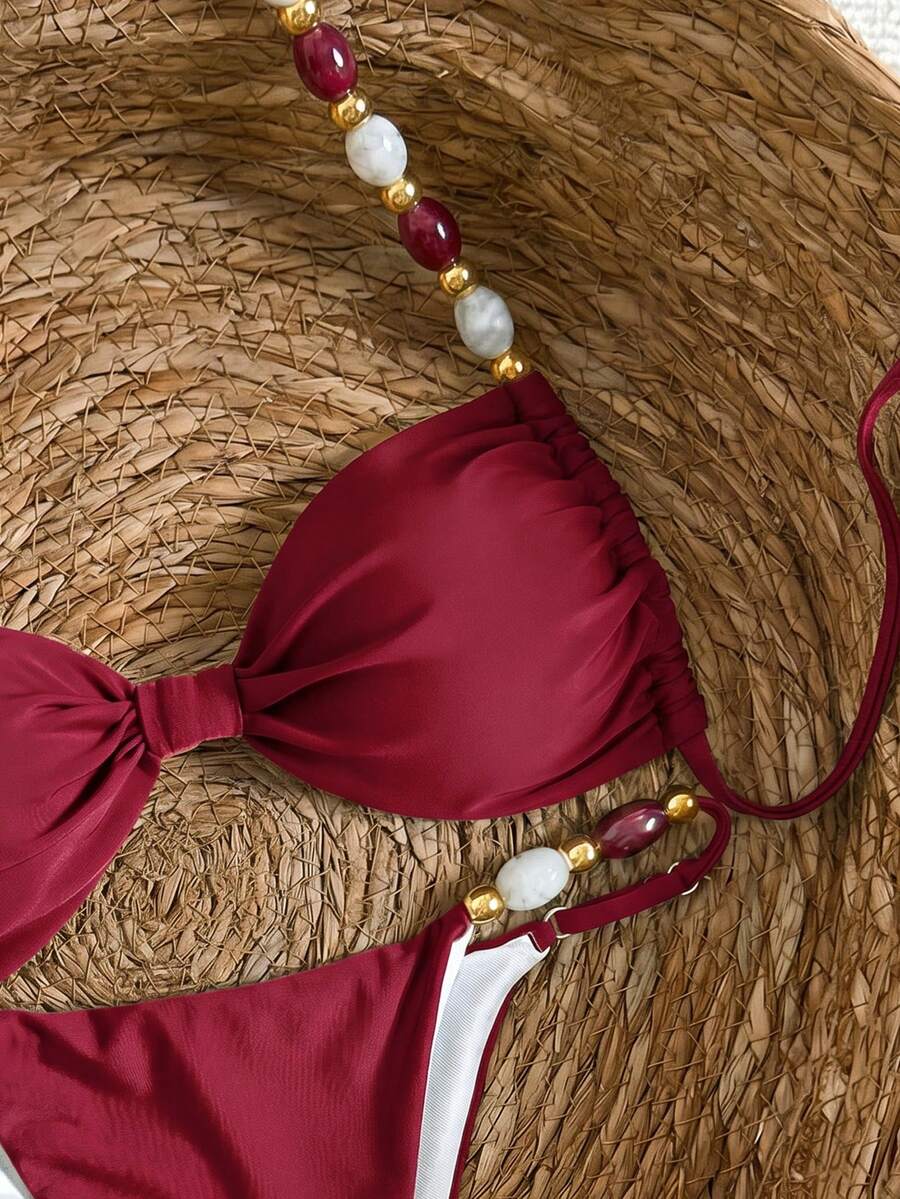 Women's green halter neck bikini set featuring color-block beaded shoulder straps, back tie detail, and high cut bottoms.