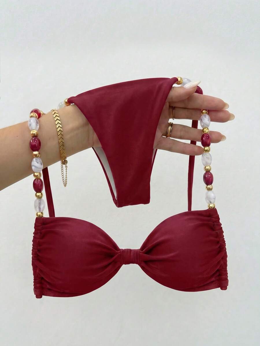 Women's green halter neck bikini set featuring color-block beaded shoulder straps, back tie detail, and high cut bottoms.