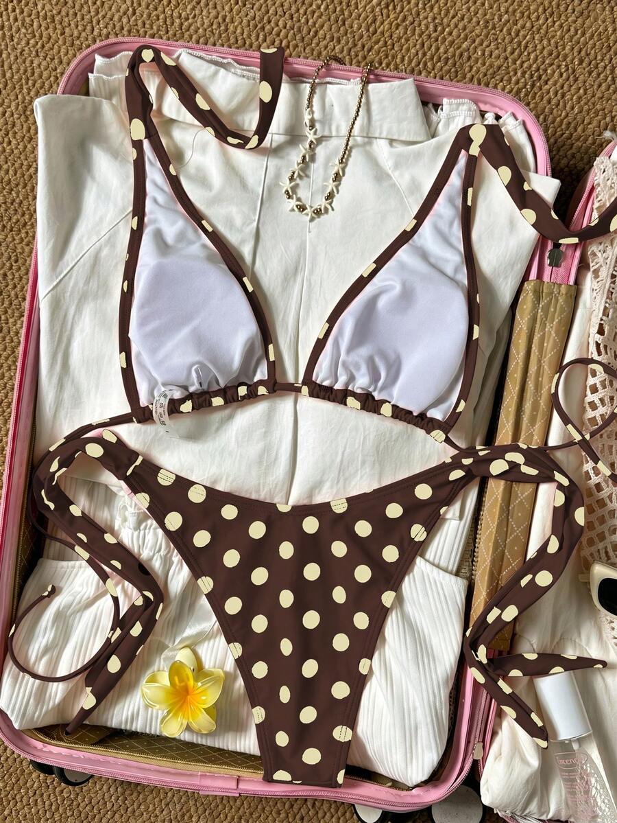Women's polka dot two-piece bikini set featuring a backless halter top with triangle cups and matching tie-side bottoms.