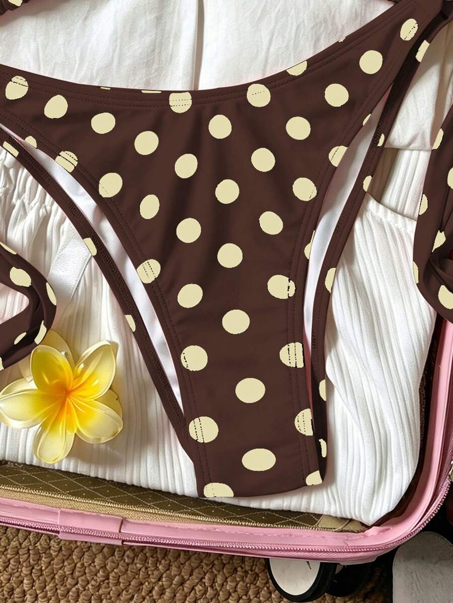 Women's polka dot two-piece bikini set featuring a backless halter top with triangle cups and matching tie-side bottoms.