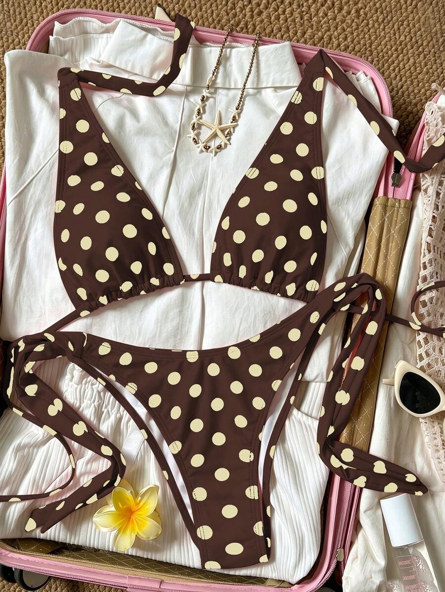 Women's polka dot two-piece bikini set featuring a backless halter top with triangle cups and matching tie-side bottoms.