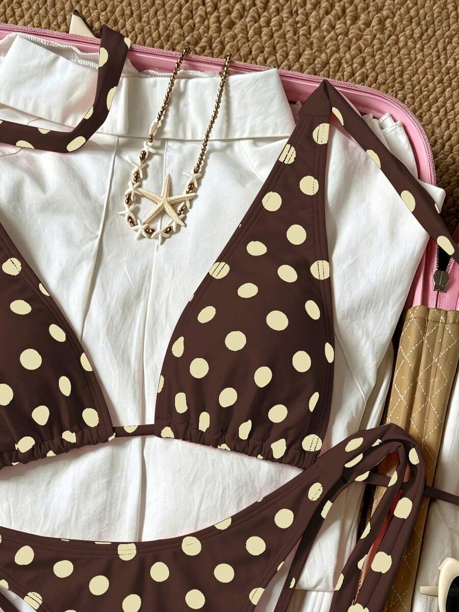 Women's polka dot two-piece bikini set featuring a backless halter top with triangle cups and matching tie-side bottoms.