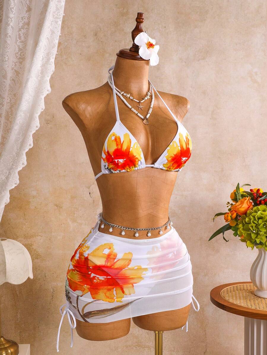 Women's black 3-piece bikini set featuring a halter triangle top with removable padding, high-waisted bottoms, and a knee-length mesh skirt with tie details.