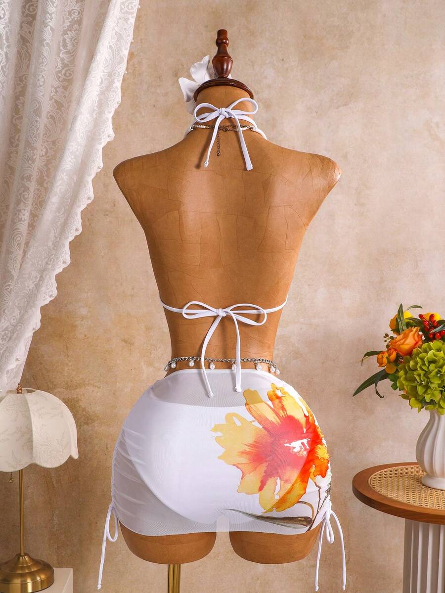 Women's black 3-piece bikini set featuring a halter triangle top with removable padding, high-waisted bottoms, and a knee-length mesh skirt with tie details.