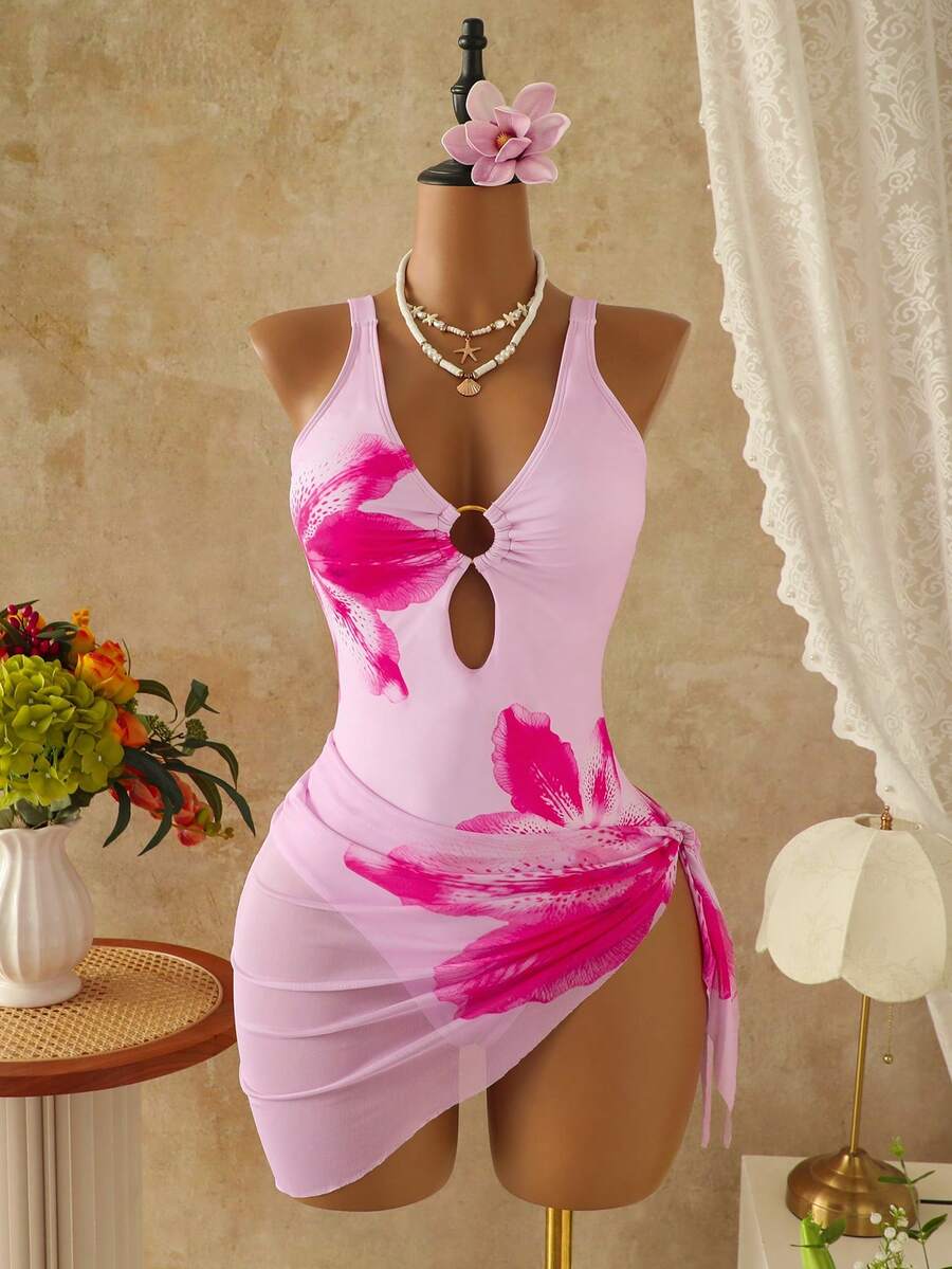 Women's black floral print plunge neck one-piece swimsuit featuring cut-out detail paired with a matching knee-length mesh cover-up skirt
