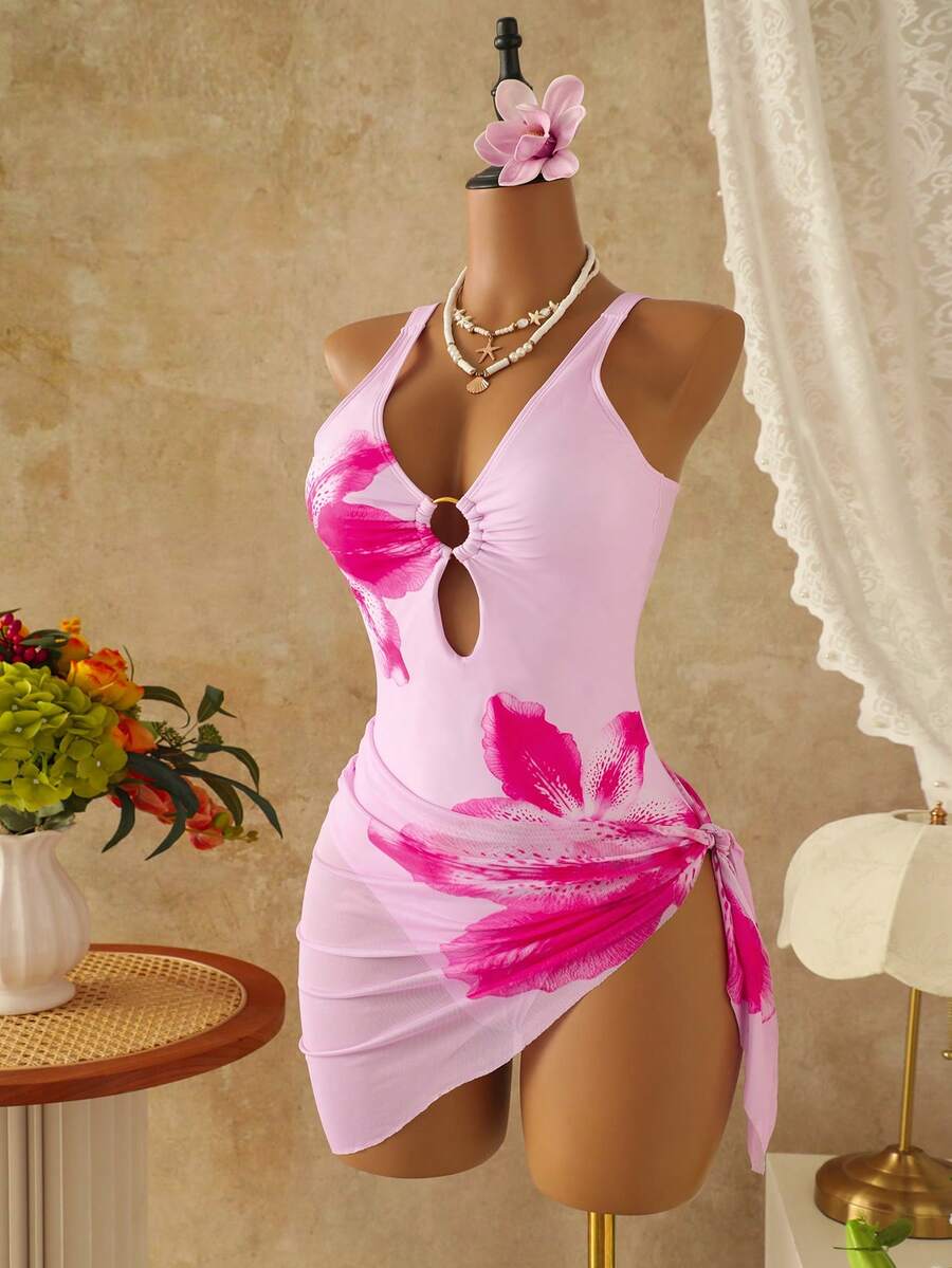 Women's black floral print plunge neck one-piece swimsuit featuring cut-out detail paired with a matching knee-length mesh cover-up skirt
