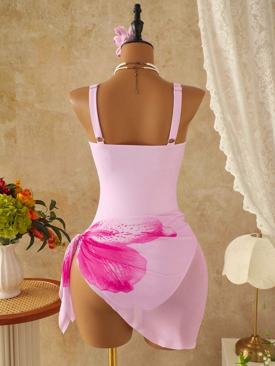 Women's black floral print plunge neck one-piece swimsuit featuring cut-out detail paired with a matching knee-length mesh cover-up skirt