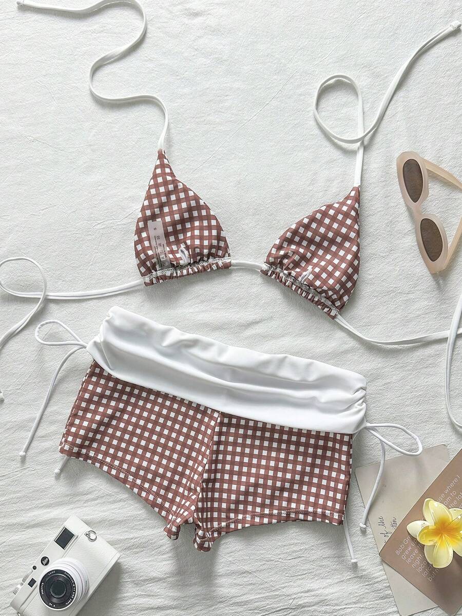 Women's halter triangle bikini top with knot detail paired with mid-waist colorblock swim shorts.