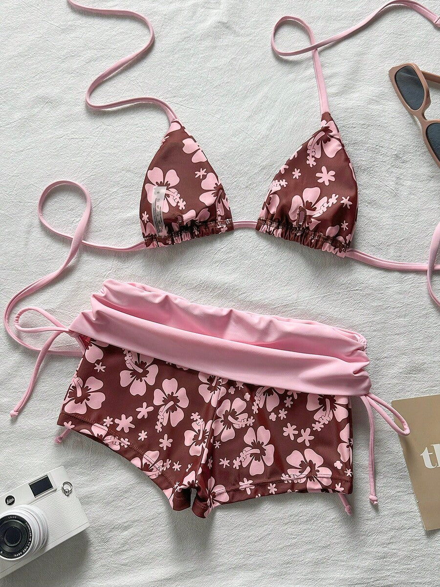 Women's halter triangle bikini top with knot detail paired with mid-waist colorblock swim shorts.