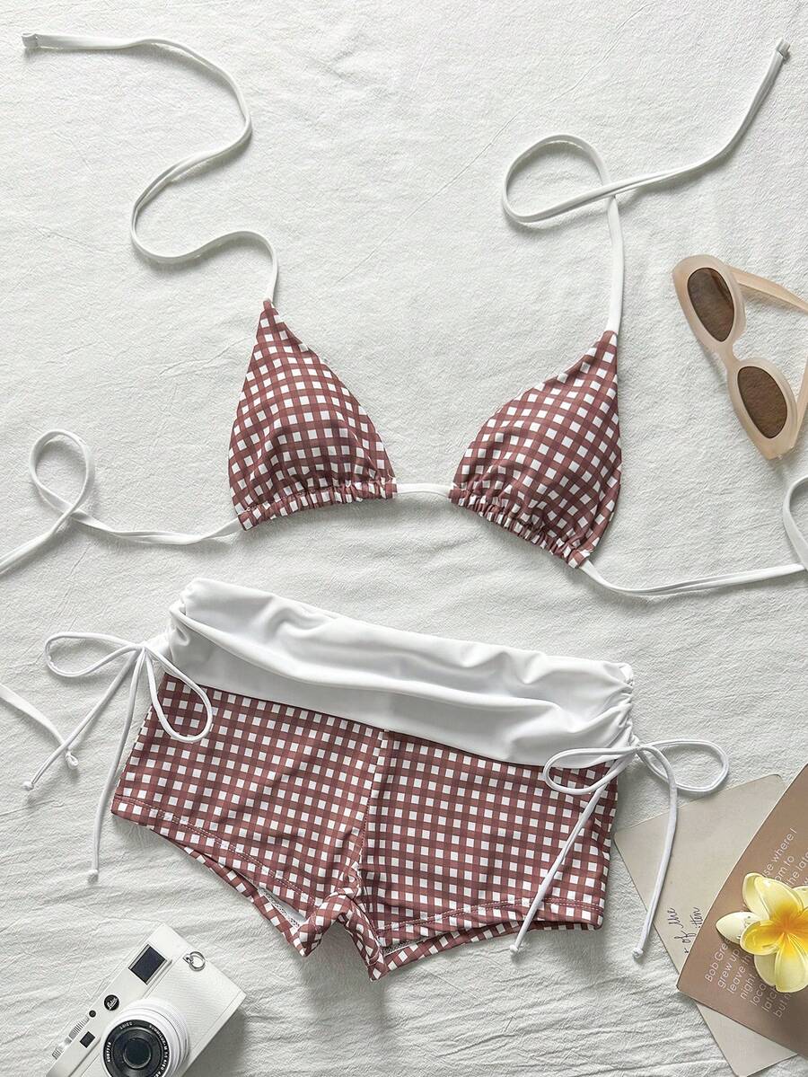 Women's halter triangle bikini top with knot detail paired with mid-waist colorblock swim shorts.