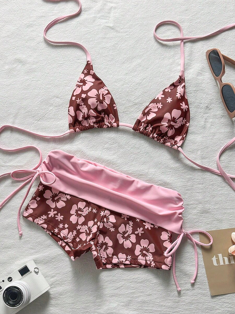 Women's halter triangle bikini top with knot detail paired with mid-waist colorblock swim shorts.