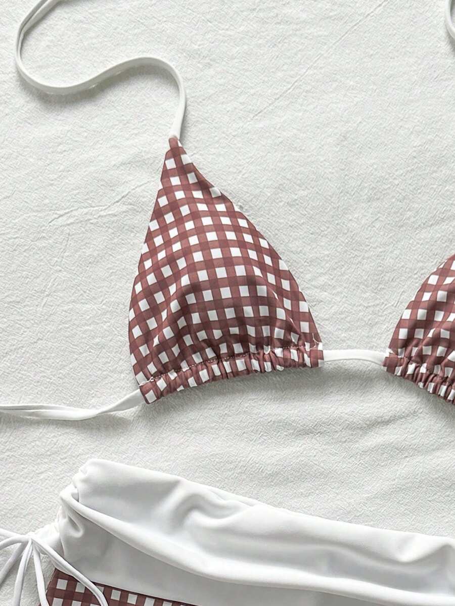 Women's halter triangle bikini top with knot detail paired with mid-waist colorblock swim shorts.