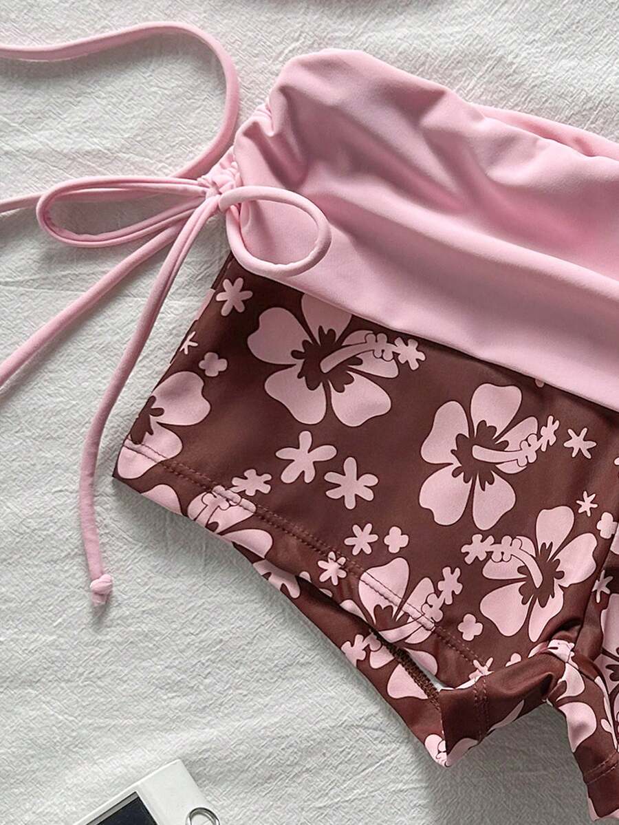 Women's halter triangle bikini top with knot detail paired with mid-waist colorblock swim shorts.