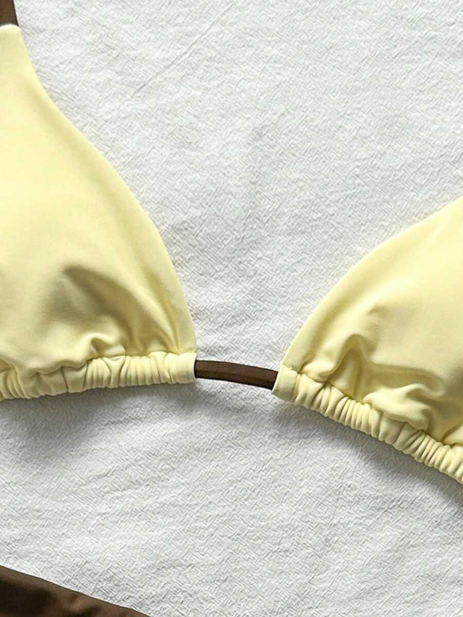 Women's halter triangle bikini top with knot detail paired with mid-waist colorblock swim shorts.
