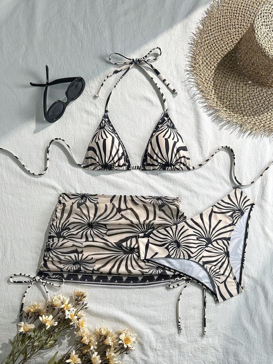 Women's black 3-piece bikini set featuring a halter triangle top with removable padding, high-waisted bottoms, and a knee-length mesh skirt with tie details.