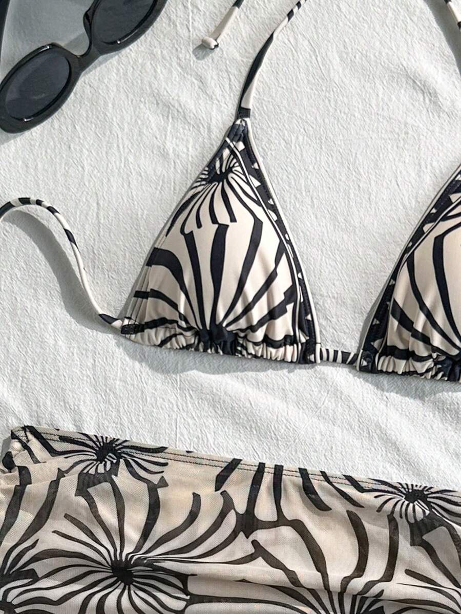 Women's black 3-piece bikini set featuring a halter triangle top with removable padding, high-waisted bottoms, and a knee-length mesh skirt with tie details.