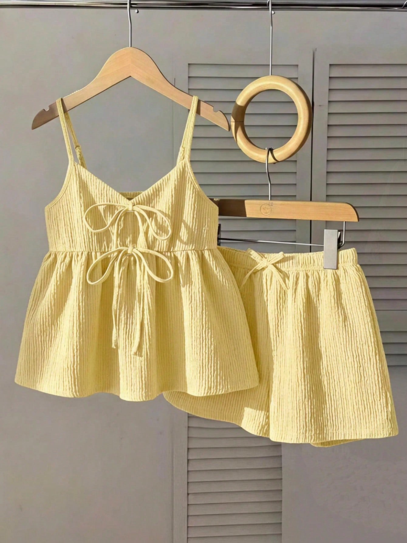 Tween girl 2-piece summer set with a black and white sleeveless striped spaghetti strap tank top with ruffle details and matching casual shorts.