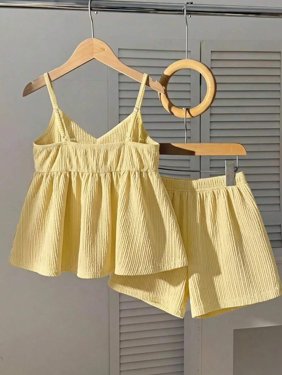 Tween girl 2-piece summer set with a black and white sleeveless striped spaghetti strap tank top with ruffle details and matching casual shorts.