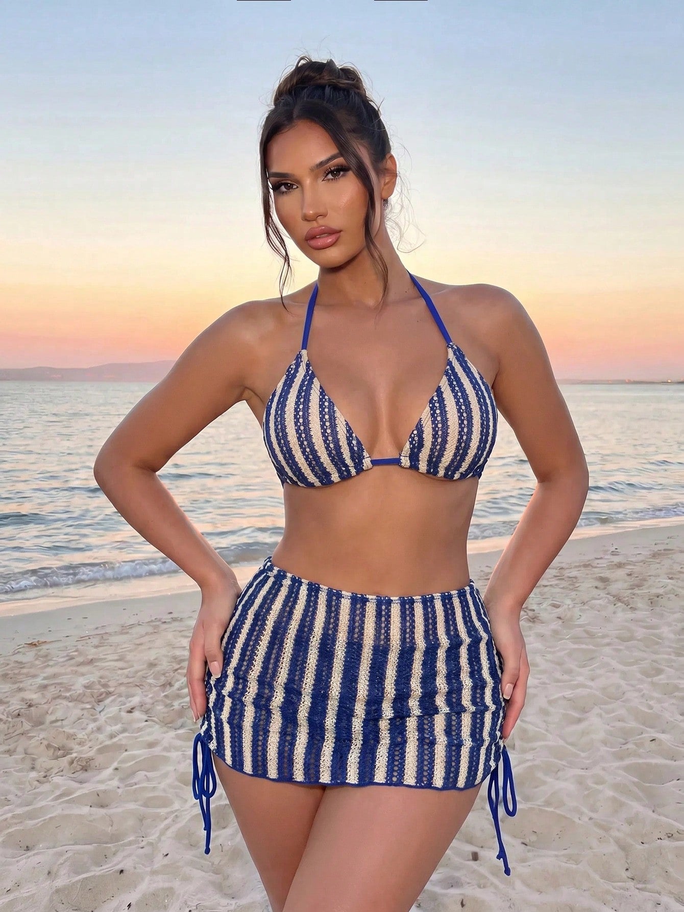 Women's black 3-piece bikini set featuring a halter triangle top with removable padding, high-waisted bottoms, and a knee-length mesh skirt with tie details.
