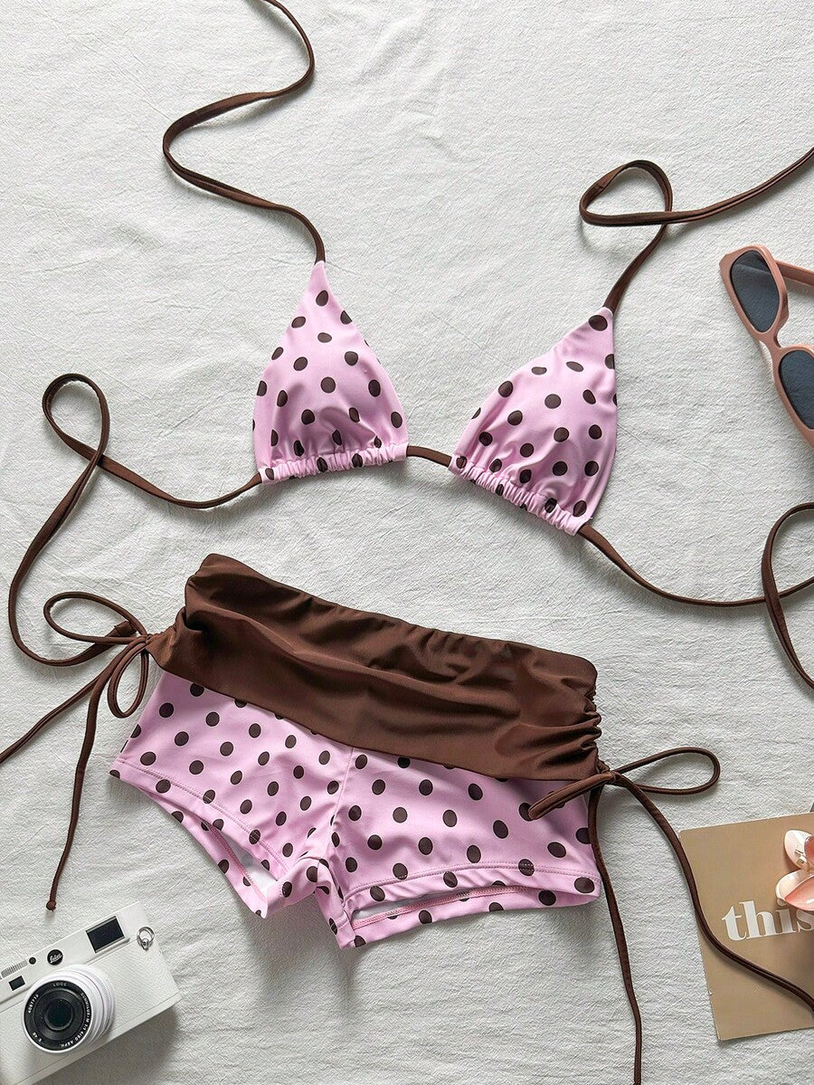 Women's halter triangle bikini top with knot detail paired with mid-waist colorblock swim shorts.