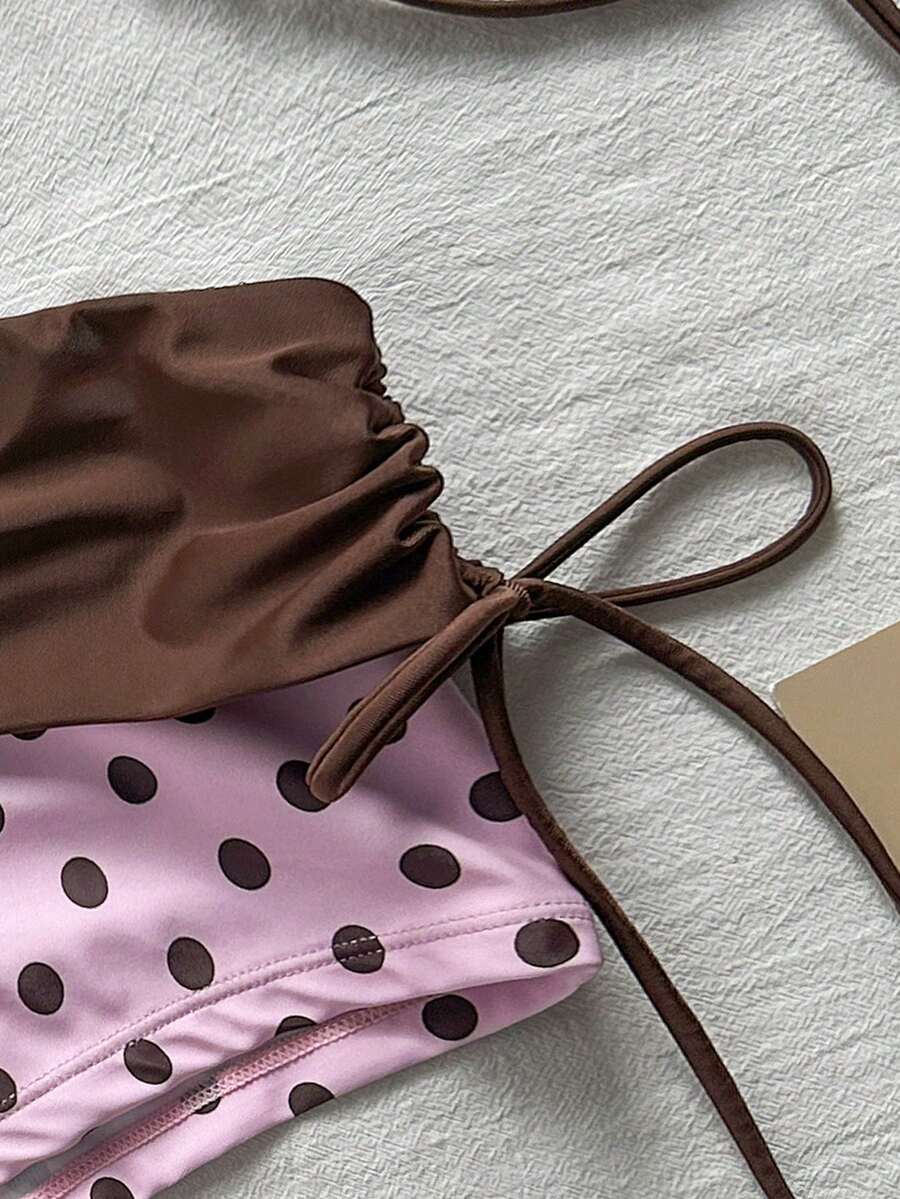 Women's halter triangle bikini top with knot detail paired with mid-waist colorblock swim shorts.