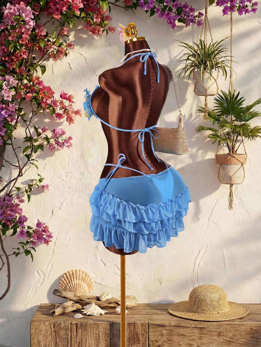 Women's 3-piece blue bikini swimwear set featuring a crop top with 3D rose accents, tie back detail, spaghetti straps, and tie-side bottoms.
