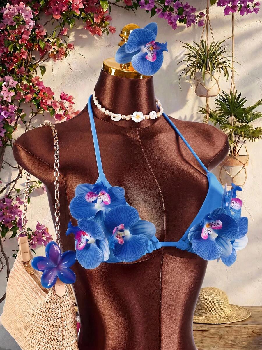Women's 3-piece blue bikini swimwear set featuring a crop top with 3D rose accents, tie back detail, spaghetti straps, and tie-side bottoms.