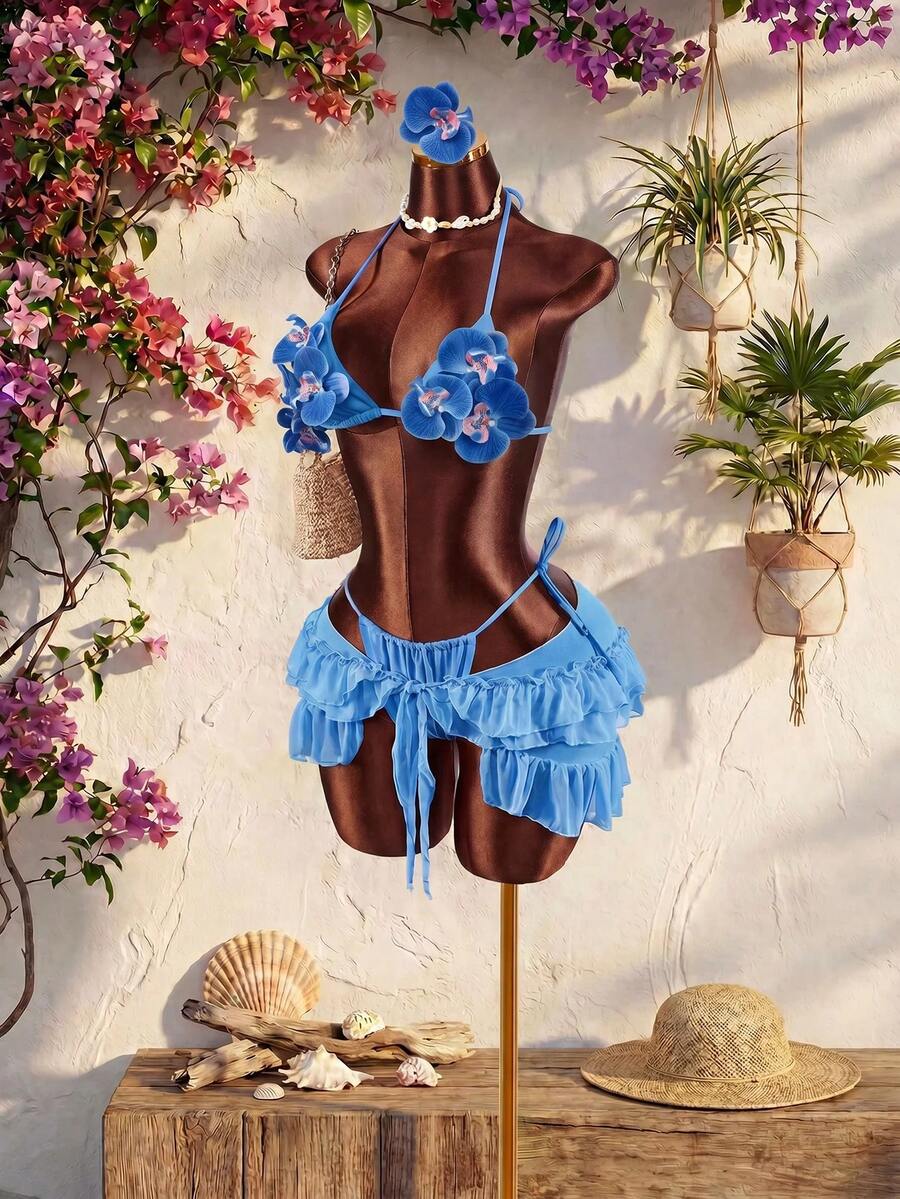 Women's 3-piece blue bikini swimwear set featuring a crop top with 3D rose accents, tie back detail, spaghetti straps, and tie-side bottoms.