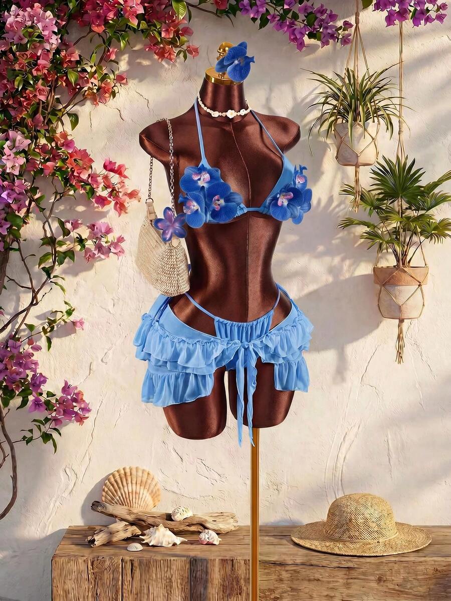 Women's 3-piece blue bikini swimwear set featuring a crop top with 3D rose accents, tie back detail, spaghetti straps, and tie-side bottoms.