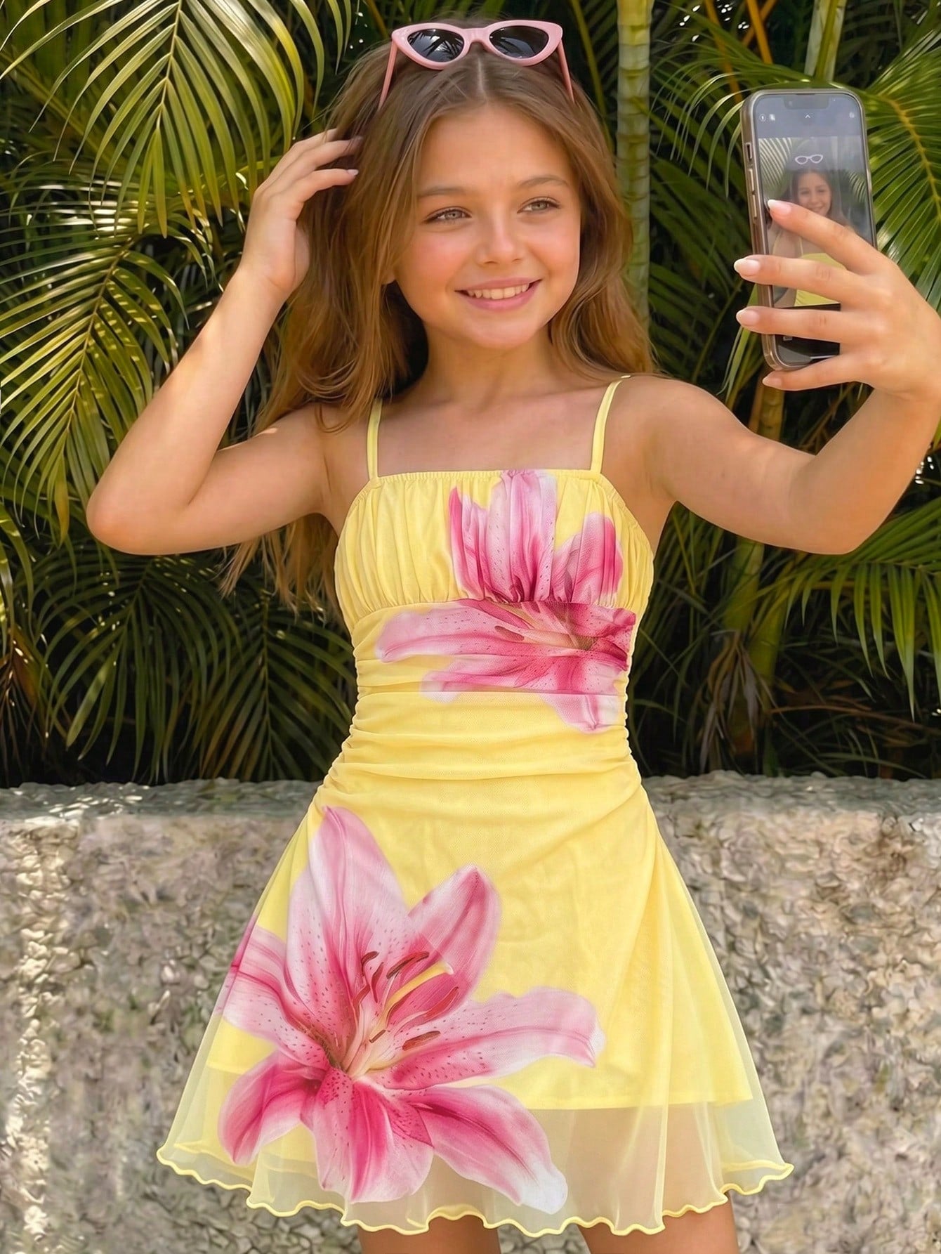 Yellow sleeveless tween girls cami dress with spaghetti straps, ruched bust, shirred details, high waist, and flared short A-line hem for vacation wear.