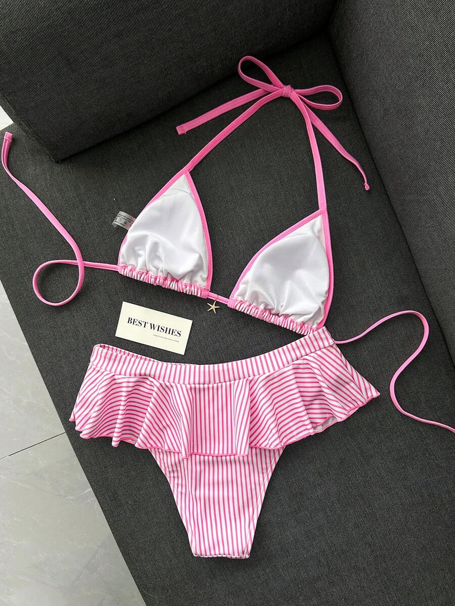 Women's 70s retro black and white polka dot bikini set featuring a halter triangle top and ultra low waist bottoms.