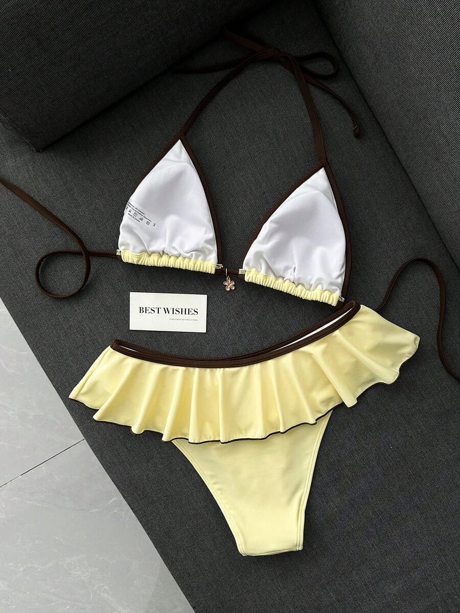 Women's 70s retro black and white polka dot bikini set featuring a halter triangle top and ultra low waist bottoms.