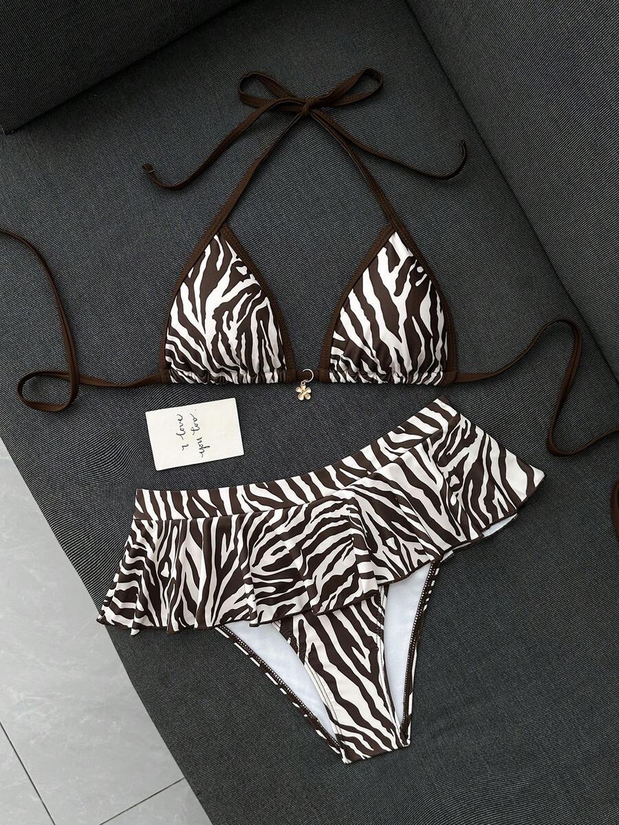 Women's 70s retro black and white polka dot bikini set featuring a halter triangle top and ultra low waist bottoms.