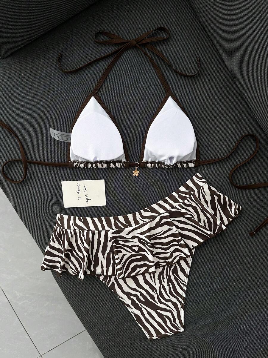 Women's 70s retro black and white polka dot bikini set featuring a halter triangle top and ultra low waist bottoms.