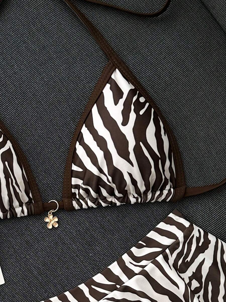 Women's 70s retro black and white polka dot bikini set featuring a halter triangle top and ultra low waist bottoms.