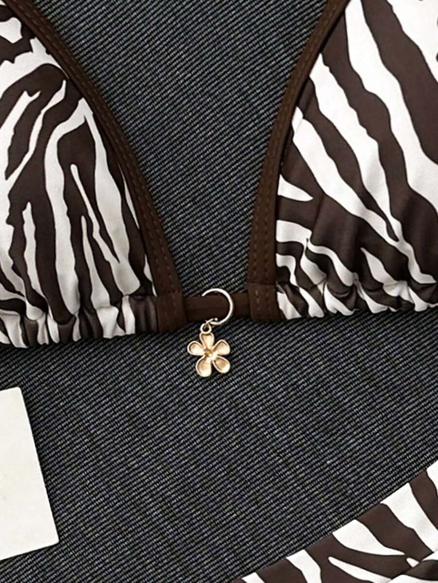 Women's 70s retro black and white polka dot bikini set featuring a halter triangle top and ultra low waist bottoms.