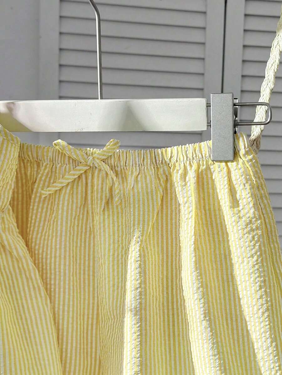 Tween girl 2-piece summer set with a black and white sleeveless striped spaghetti strap tank top with ruffle details and matching casual shorts.