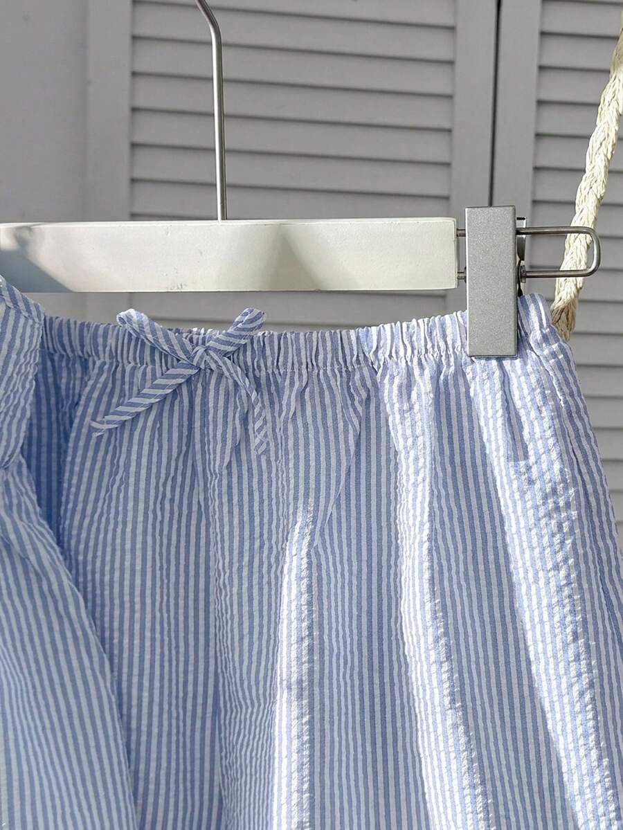 Tween girl 2-piece summer set with a black and white sleeveless striped spaghetti strap tank top with ruffle details and matching casual shorts.