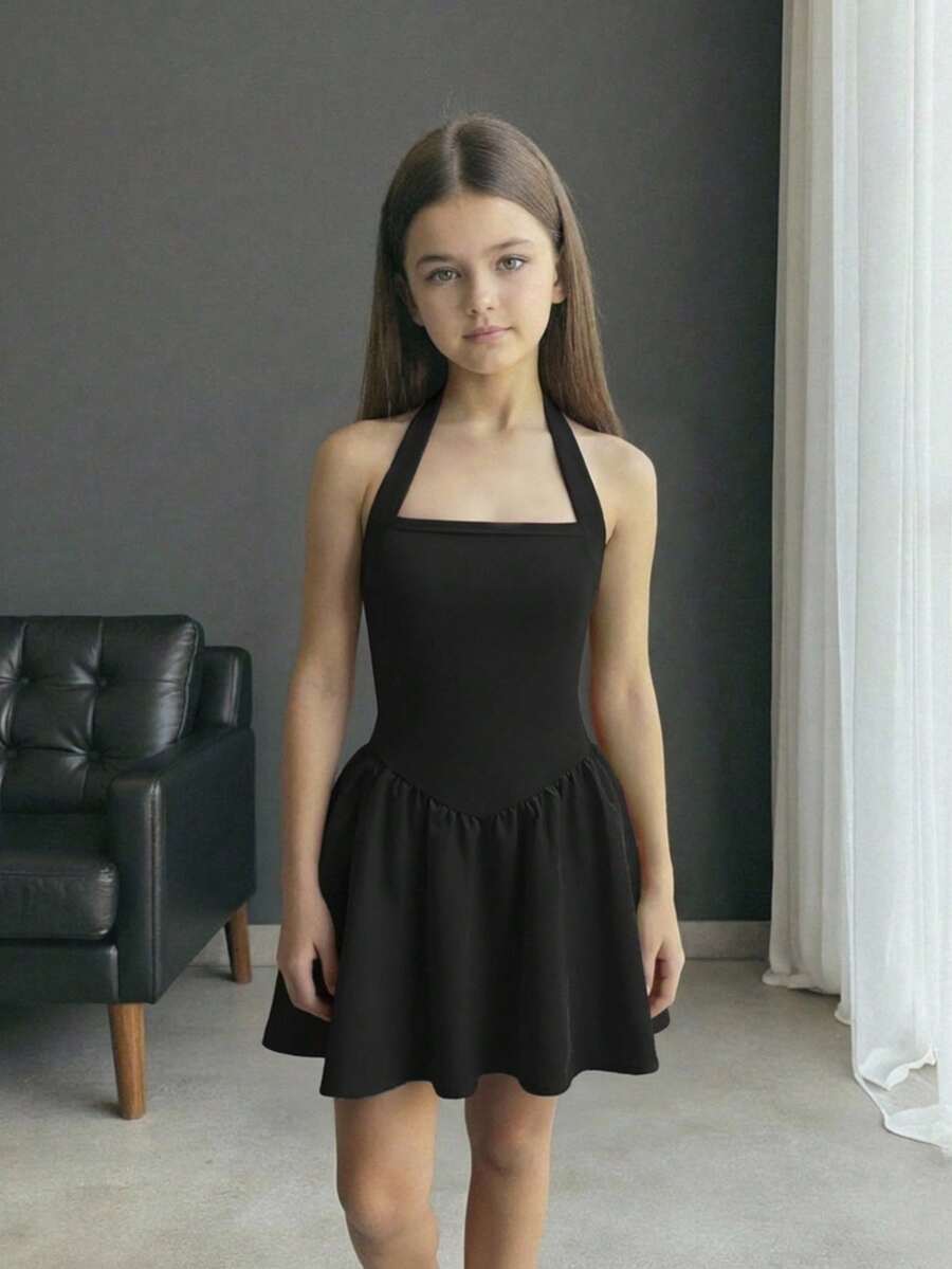 Black sleeveless halter polka dot mini dress for tween girls featuring a high waist and flared hem