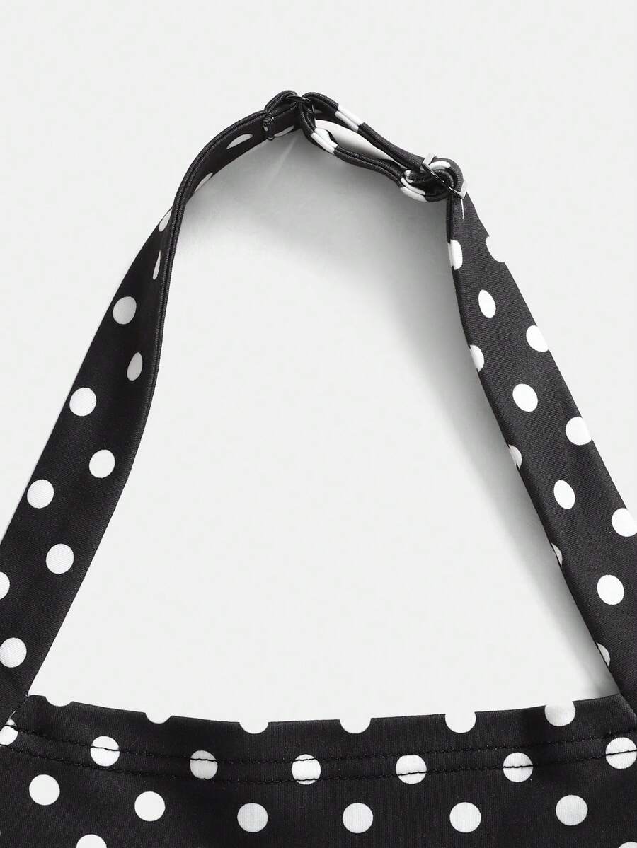 Black sleeveless halter polka dot mini dress for tween girls featuring a high waist and flared hem