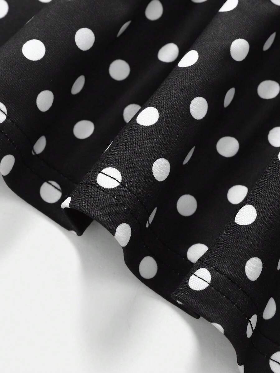 Black sleeveless halter polka dot mini dress for tween girls featuring a high waist and flared hem