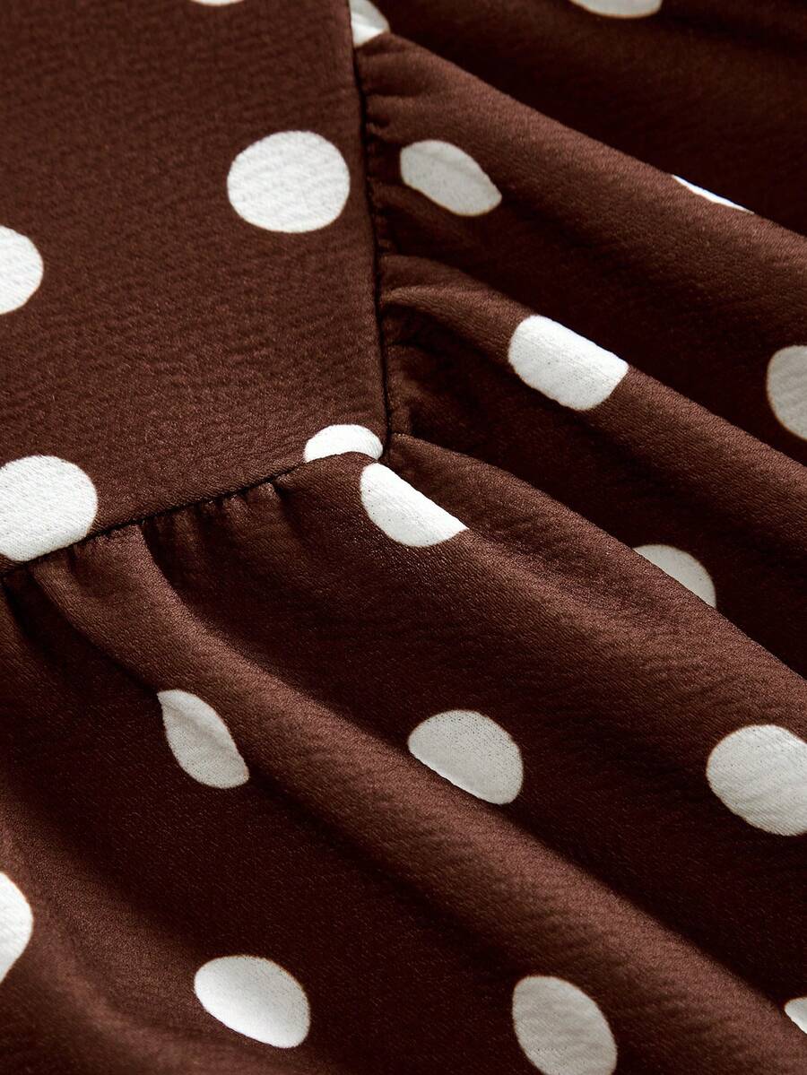 Black sleeveless halter polka dot mini dress for tween girls featuring a high waist and flared hem