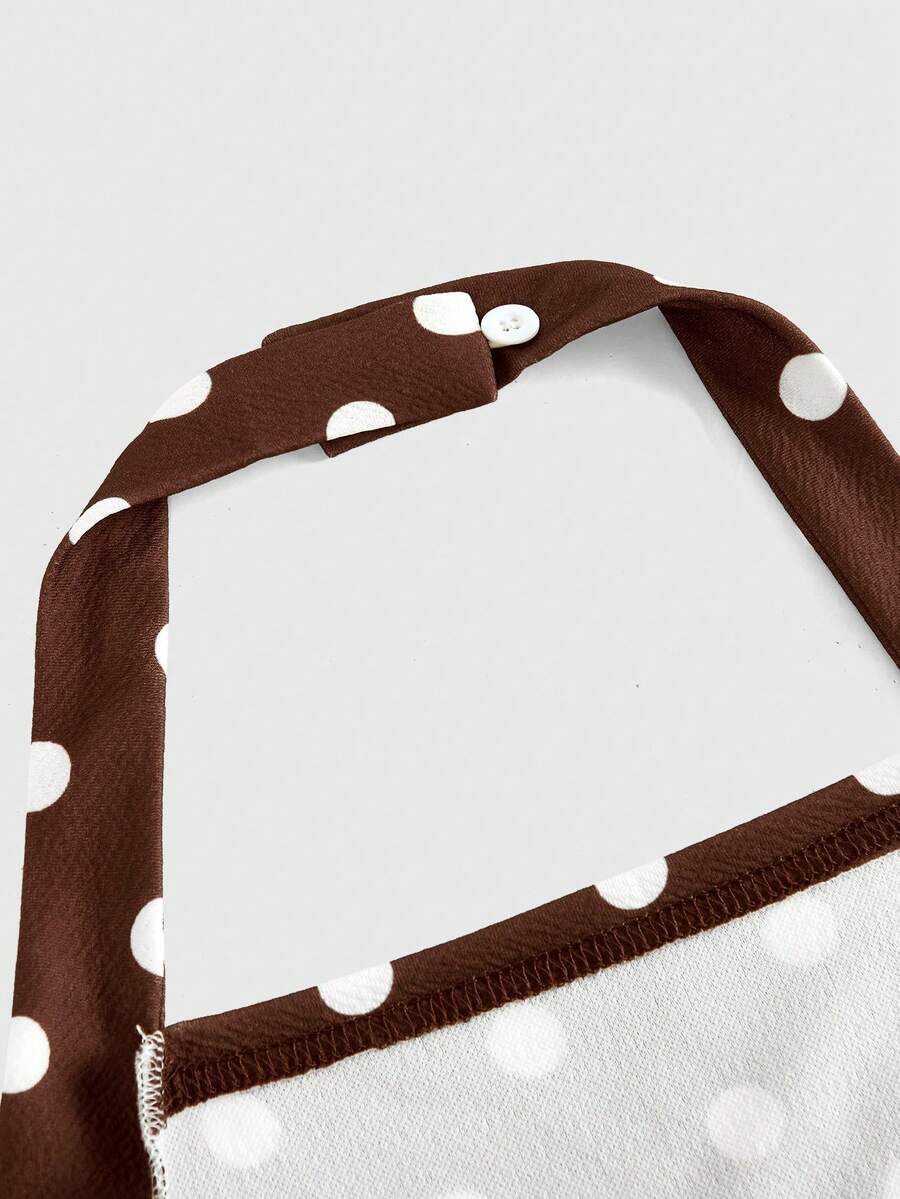 Black sleeveless halter polka dot mini dress for tween girls featuring a high waist and flared hem