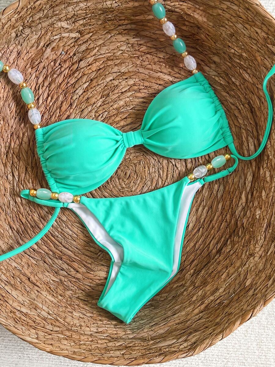 Women's green halter neck bikini set featuring color-block beaded shoulder straps, back tie detail, and high cut bottoms.