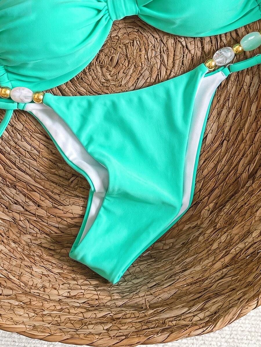 Women's green halter neck bikini set featuring color-block beaded shoulder straps, back tie detail, and high cut bottoms.