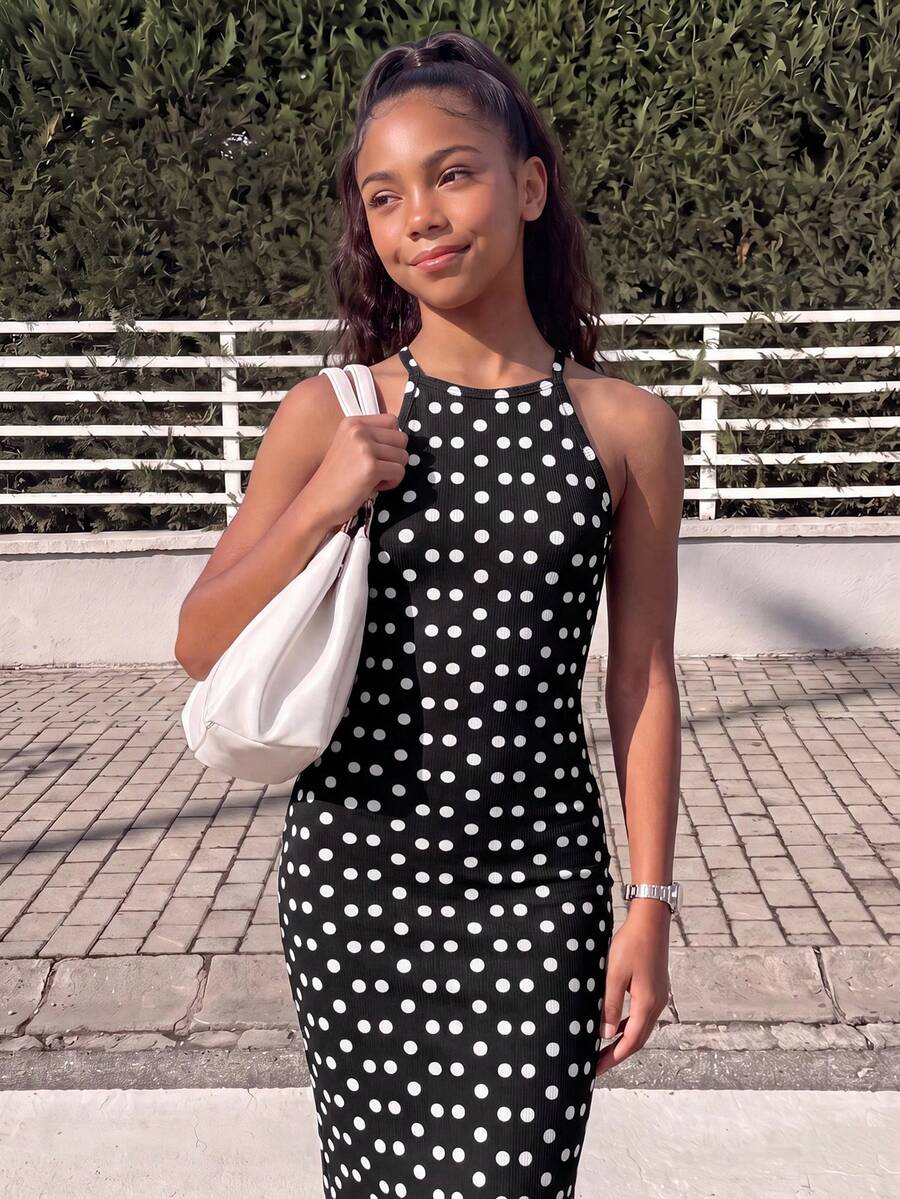Tween girl black mini dress with halter neckline, backless design, tiered layer detail, high waist, flounce hem, and sleeveless slim fit.