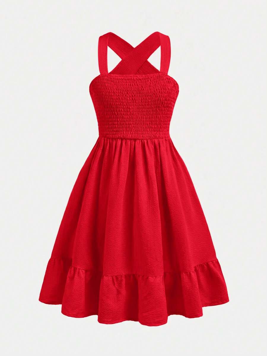 Pink sleeveless tween girls vacation dress with all-over fruit and vegetable print, strap neckline, belted high waist, cut-out detail, and flared ruffle hem.