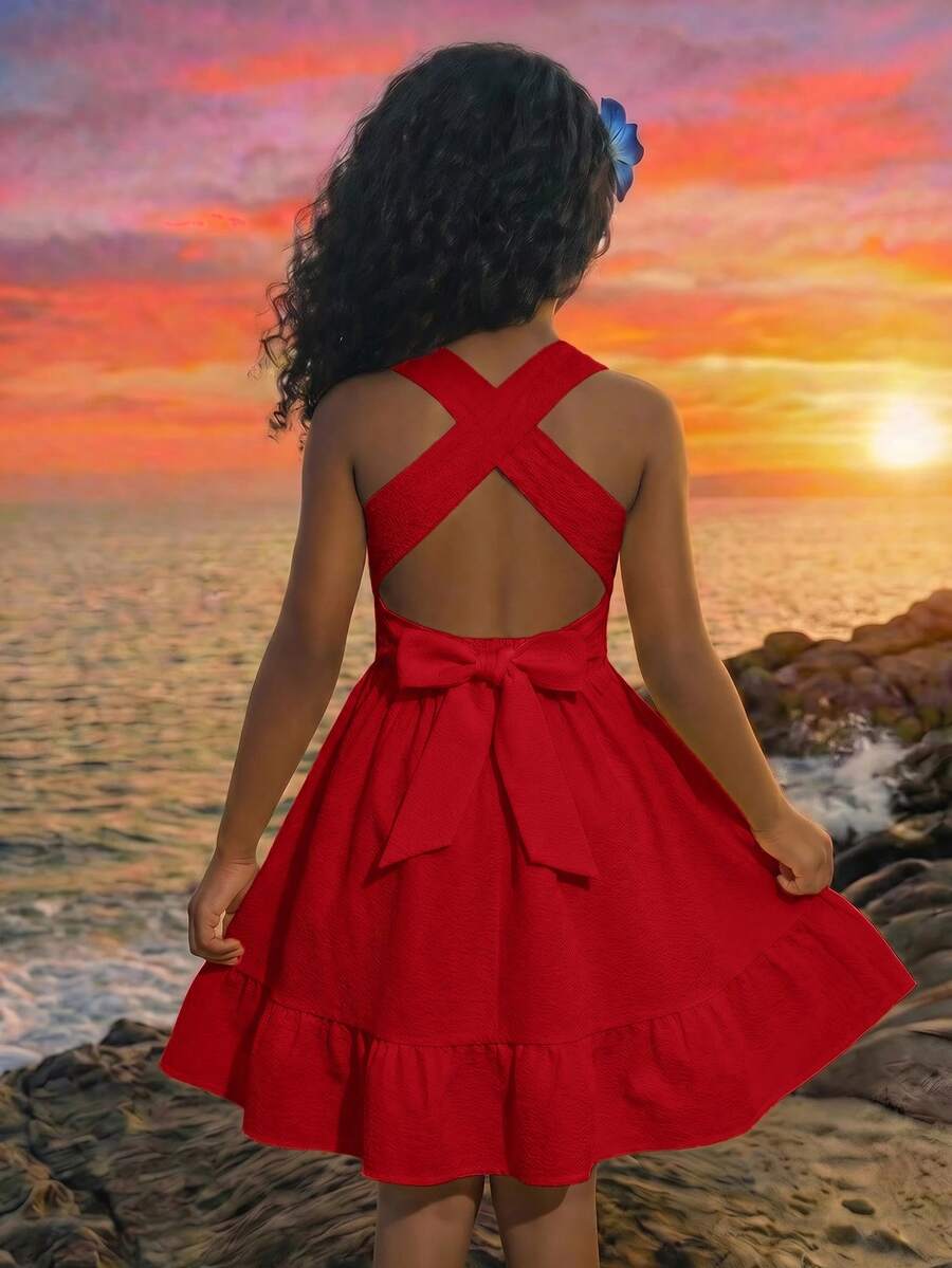 Pink sleeveless tween girls vacation dress with all-over fruit and vegetable print, strap neckline, belted high waist, cut-out detail, and flared ruffle hem.
