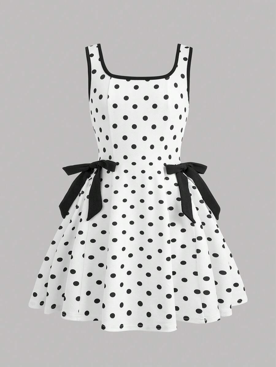 Black and white polka dot cami dress for tween girls featuring a square neckline, high waist, and flared short A-line hem.